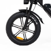 Close-up of a black fat-tire bicycle wheel with a silver disc brake, black fender, and part of the black frame on a white background.
