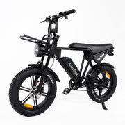 A black Atlas Trek electric fat tire bike with a headlight, front cargo rack, and rear suspension, photographed on a seamless white background.