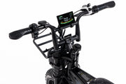 Close-up of a black electric bicycle handlebar assembly with a digital display screen, black grips, and a front cargo rack on a white background.