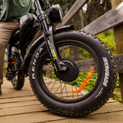 Close-up of a bicycle wheel with Kenda tires on a wooden surface