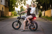 Man and woman riding a small motorcycle together on a street.