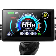 A digital display screen for a bicycle or e-bike dashboard, mounted on a black handlebar clamp. The screen shows a speedometer graphic with blue, red, and white indicators, battery percentage, and other metrics.