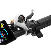 Close-up of a bicycle or e-bike handlebar setup with a Shimano TSP500 rear derailleur mounted near the brake lever, alongside part of a digital display screen, on a white background.