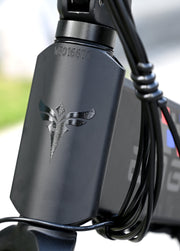 Close-up of a black electronic device with a logo on a blurred background
