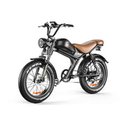 A black electric fat tire bike with a brown leather saddle, black handlebars, and Kenda tires, shown from a three-quarters front angle on a white background.