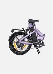 A compact electric bicycle in a light lavender-purple frame with black components, a black saddle, and a black rear rack, shown on a clean light gray background.