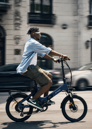 Man riding a blue electric bike on a city street
