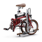 Red folding bicycle with brown seat and handlebar grips on a white background